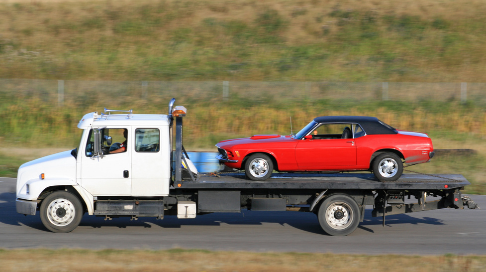 Tow Truck Hauling A New Red Car
